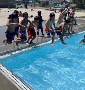 Kids jumping into the pool.